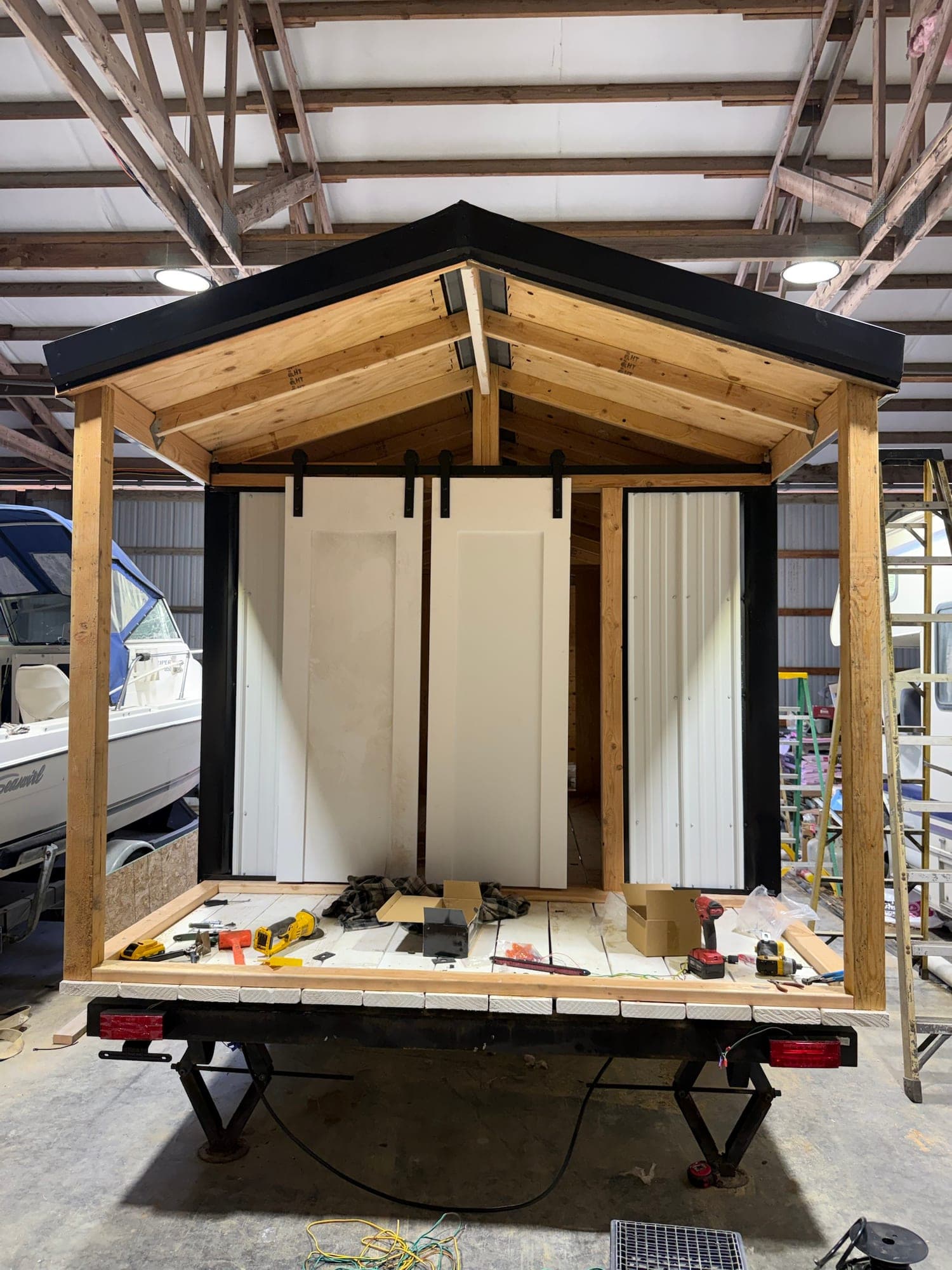 White sliding barn doors hung on a black track across the front of the stall